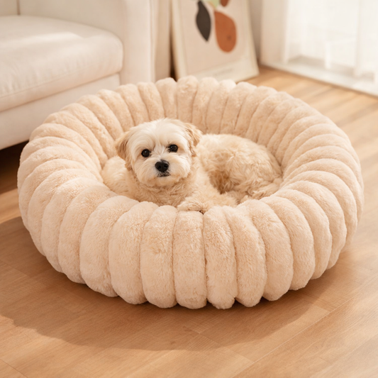 Calming dog bed and cat bed made with ultra-soft plush fabric and raised edges, designed as an anti-anxiety pet bed for small to medium dogs and cats, providing a cozy, warm and secure sleeping space, modern round pet bed in neutral color placed in a minimalist home interior, ideal for puppies, kittens and pets that love to curl up, perfect as a soft dog bed for living room or comfortable cat bed for bedroom